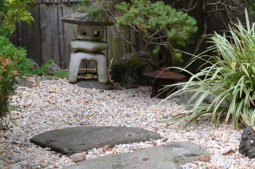 Rocks, shrubs, and a small shrine in a Japanese Garden.